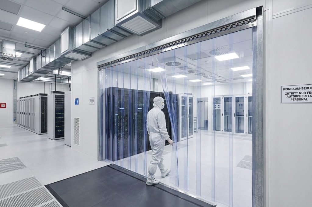 Reinraumvorhang aus PVC-Streifen als Zugang zu einem Serverraum, Techniker im Schutzanzug beim Durchgang – EASY HANG
