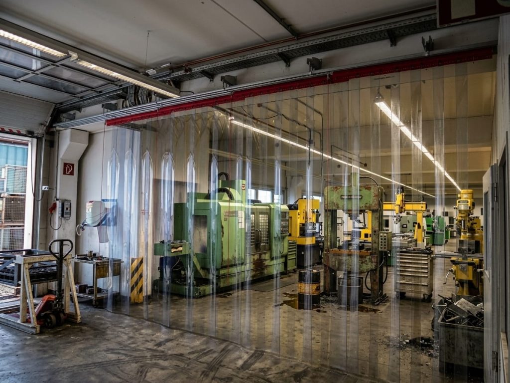 PVC-Schallschutzvorhang schirmt Werkzeugmaschinen in einer Werkhalle ab – EASY HANG GmbH