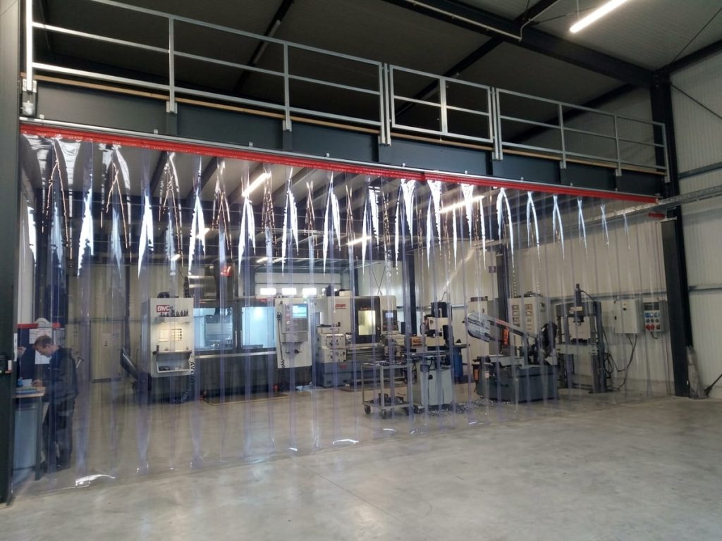 Raumhoher PVC-Schallschutzvorhang trennt einen Fertigungsbereich in der Halle ab – EASY HANG GmbH